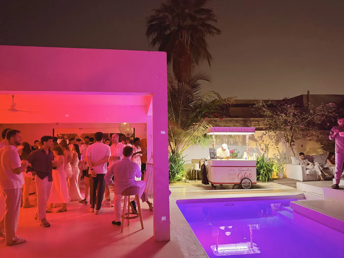The villa pool lit pink at night