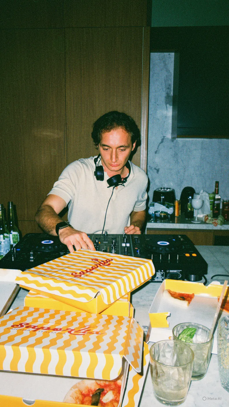 DJ playing behind a stack of pizza boxes